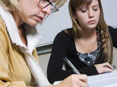 Two Girls Write on Paper